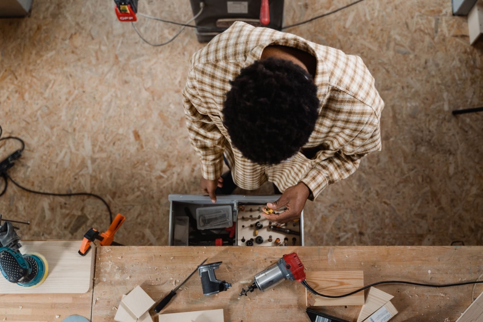 Carpenter shaping wood at a workshop bench