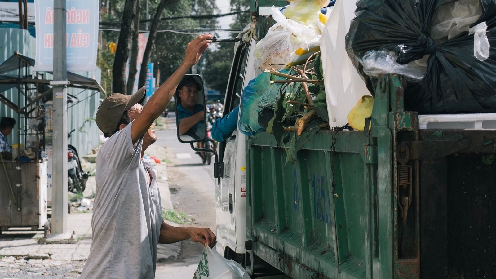 Worker loading waste into a collection truck