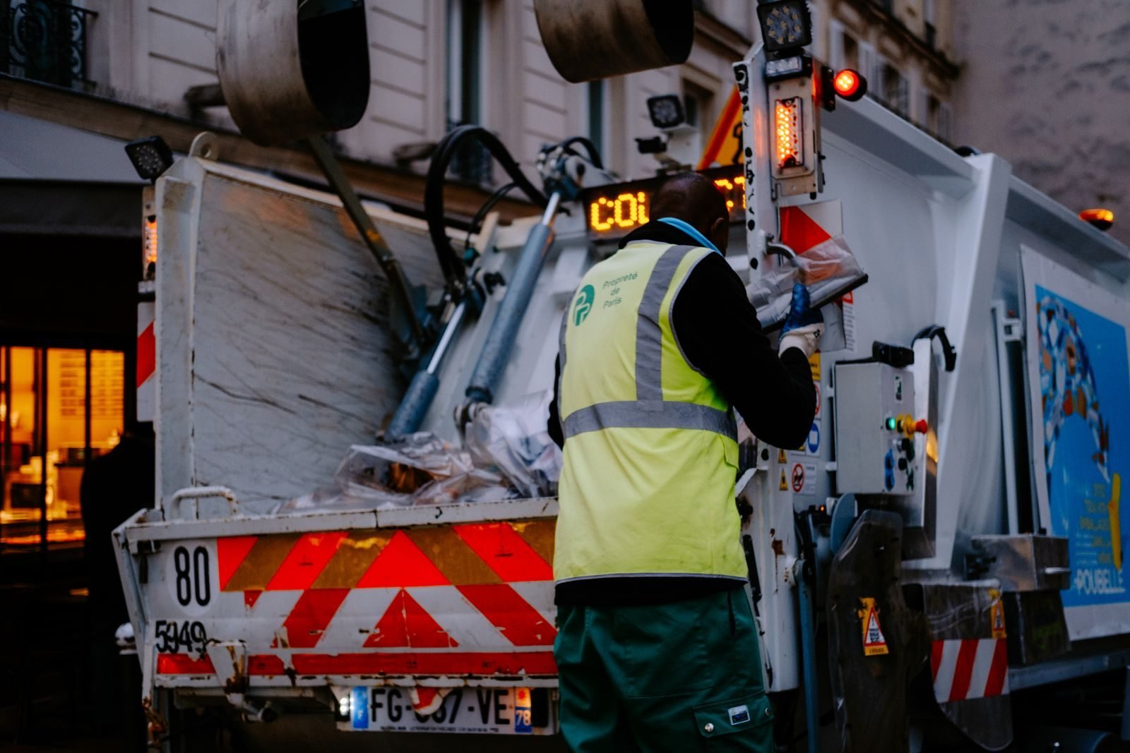 Waste collection worker beside a refuse truck