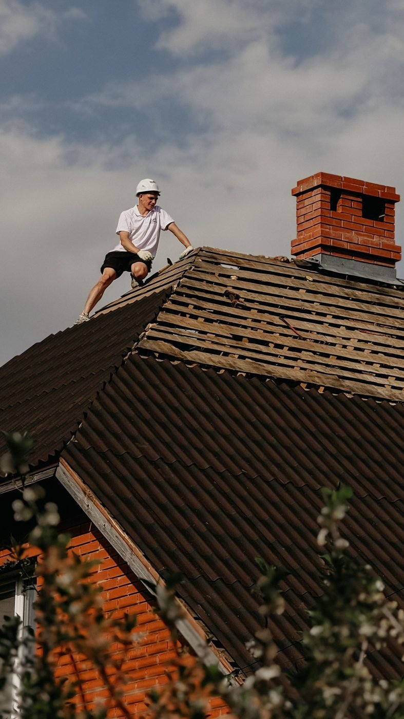 Worker repairing a residential brick home roof